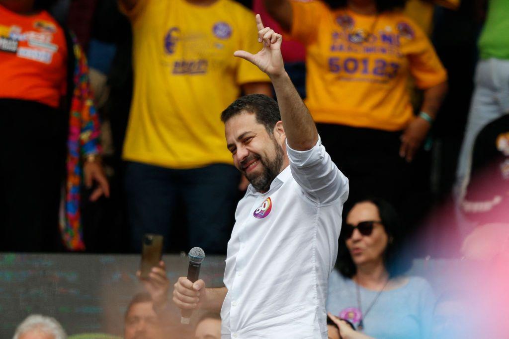 Foto mostra Boulos sorridente em evento de campanha durante o primeiro turno das eleições municipais fazendo o L com a mão, indicação de apoio a Lula