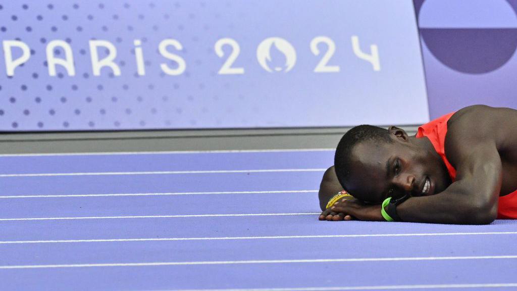 El keniano Zablon Ekhal Ekwam reacciona tras caerse mientras competía en la prueba de 400 metros masculinos de atletismo