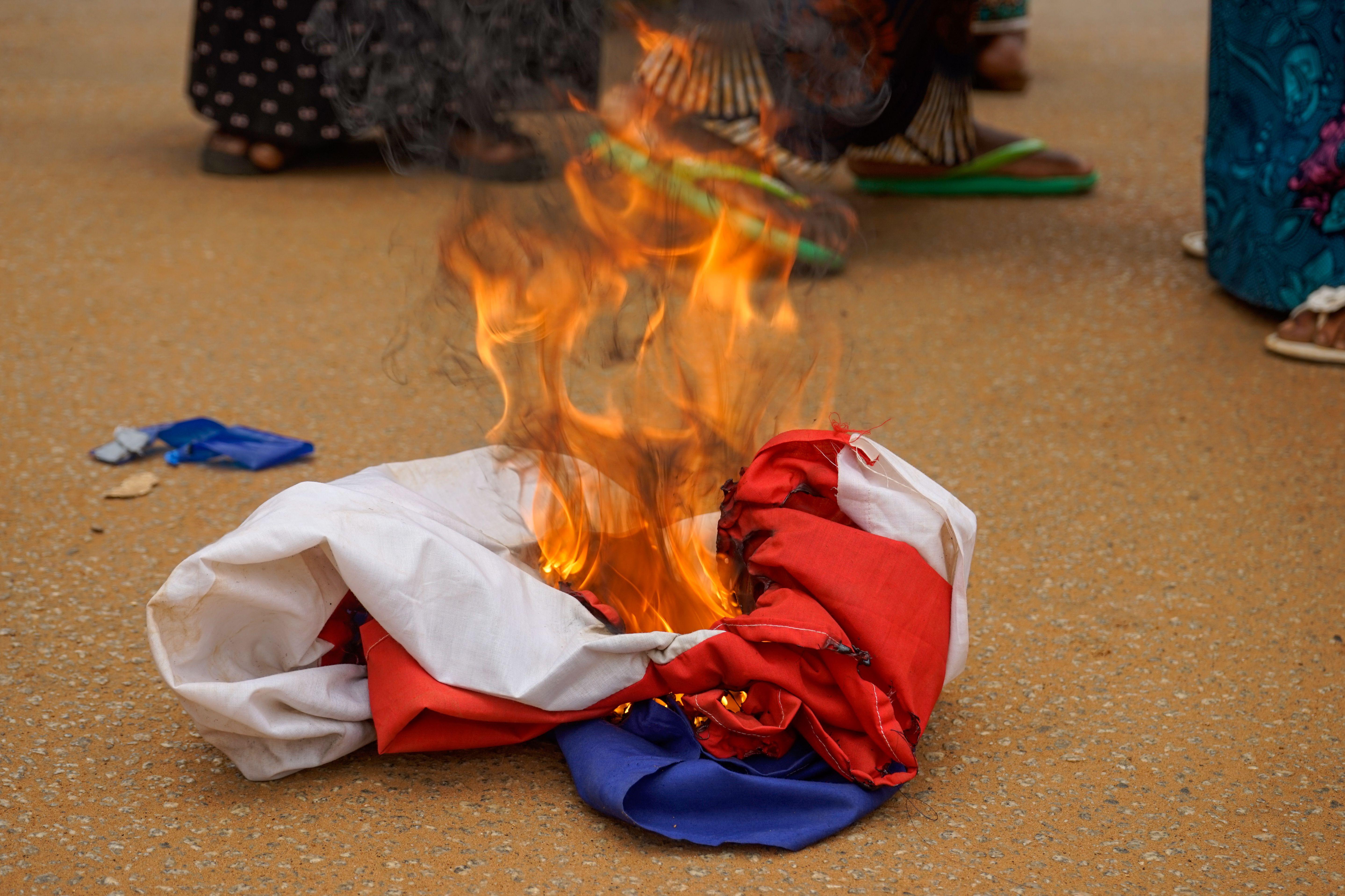 أفراد يحرقون العلم الفرنسي خلال مظاهرة ضد الجيش الفرنسي