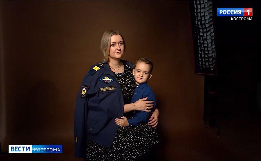 A mulher de um soldado russo posa com o uniforme dele ao lado de uma criança