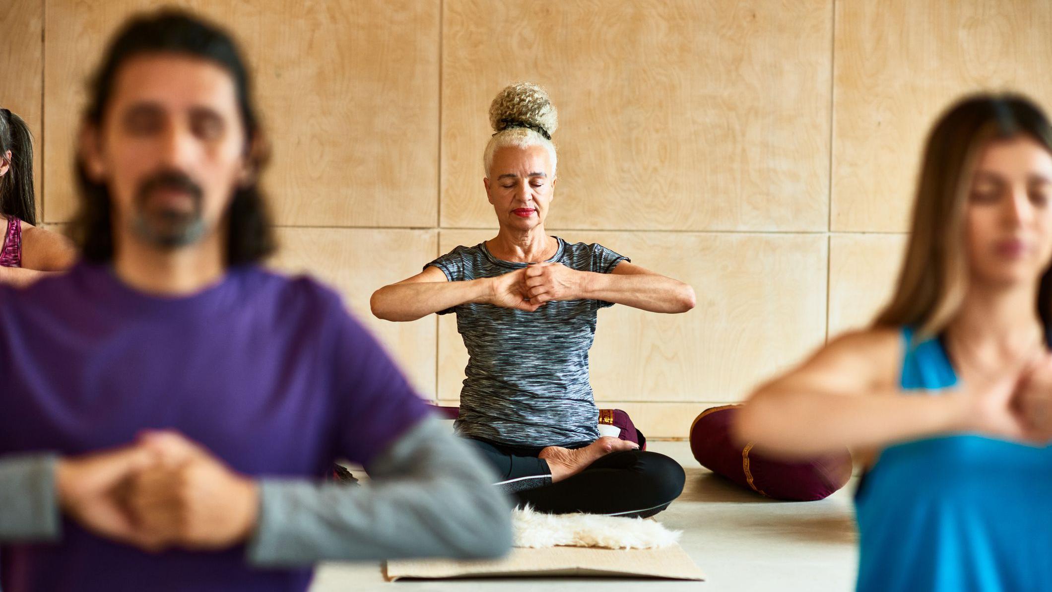 Un grupo de hombres y mujeres de distintas edades practicando yoga