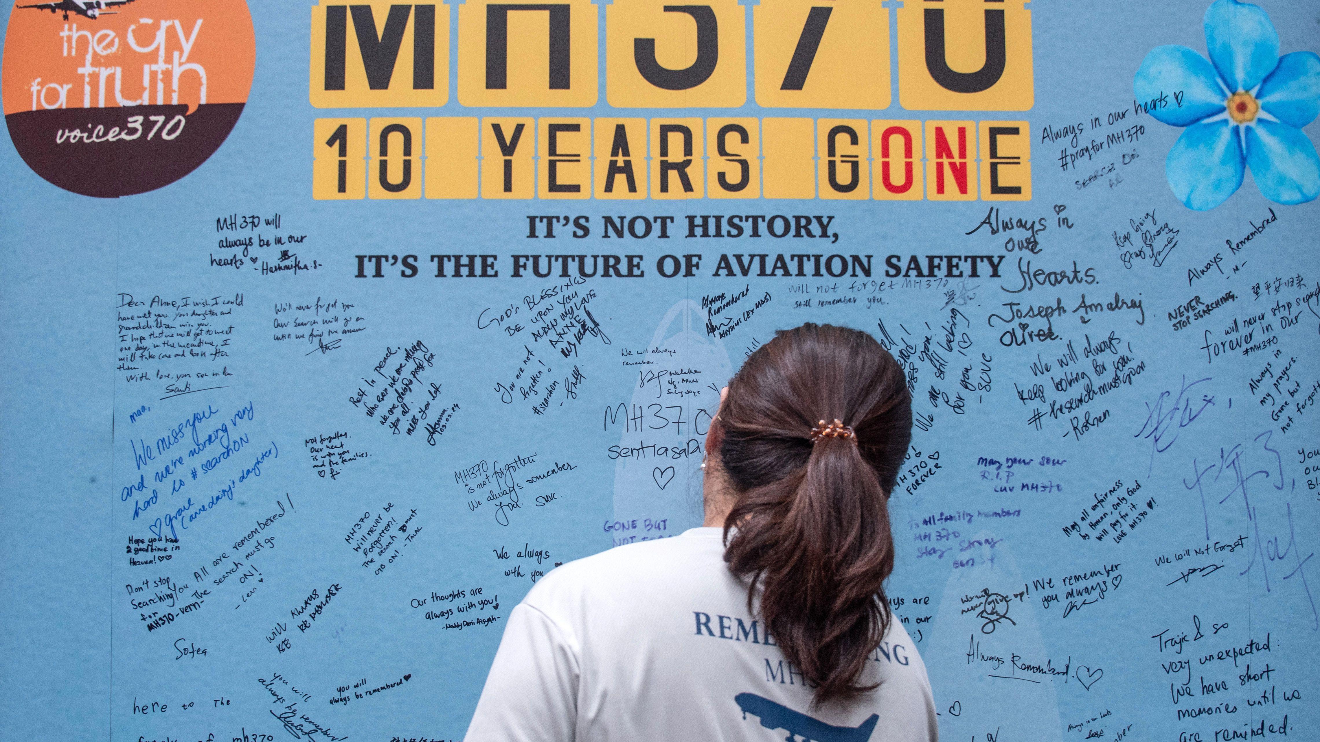 Familiares de los pasajeros del vuelo de Malaysia Airlines que desapareció misteriosamente hace 10 años escriben mensajes en el Día del Recuerdo del MH370 en Petaling Jaya, Malasia.