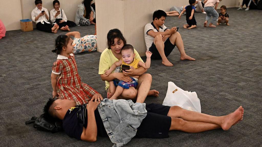 Orang-orang di Vietnam berlindung dari panas dengan menyambangi pusat perbelanjaan