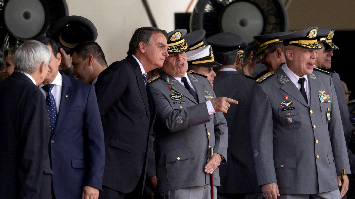 O ex-presidente do Brasil, Jair Bolsonaro, fala com o então comandante do Exército Marco Antonio Freire Gomes durante cerimônia de formatura na Academia Militar das Agulhas Negras em Resende, Rio de Janeiro, em 26 de novembro de 2022