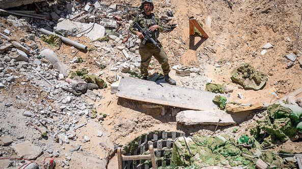 Seorang tentara Israel berdiri di samping pintu masuk terowongan yang digunakan oleh Hamas di Gaza