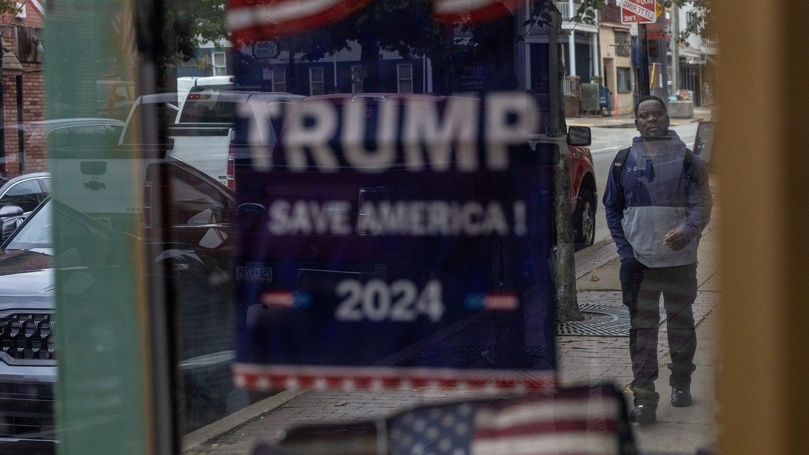 Cartaz com os dizeres 'Trump Save America' em porta de comércio