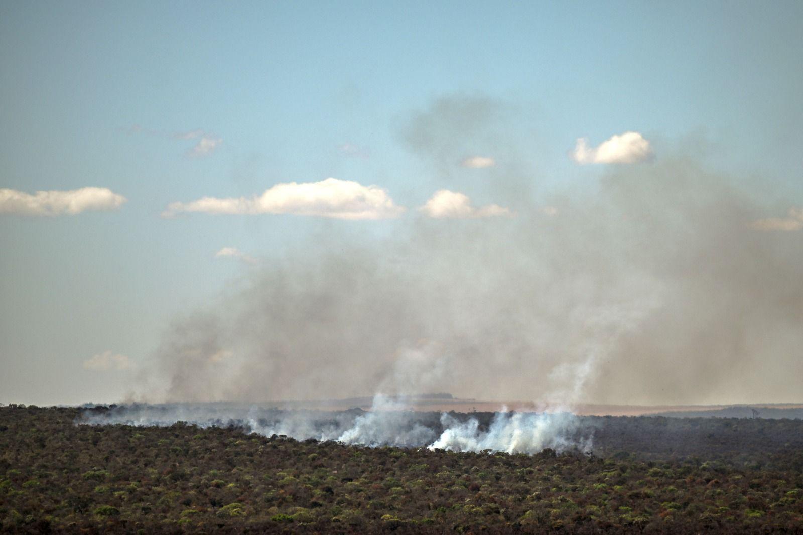 Foto aérea mostra fumaça saindo da vegetação do cerado e subindo para o céu