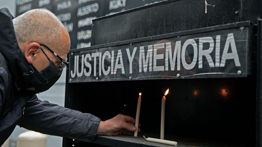 Hombre deja una vela en recuerdo a las víctimas de la AMIA.