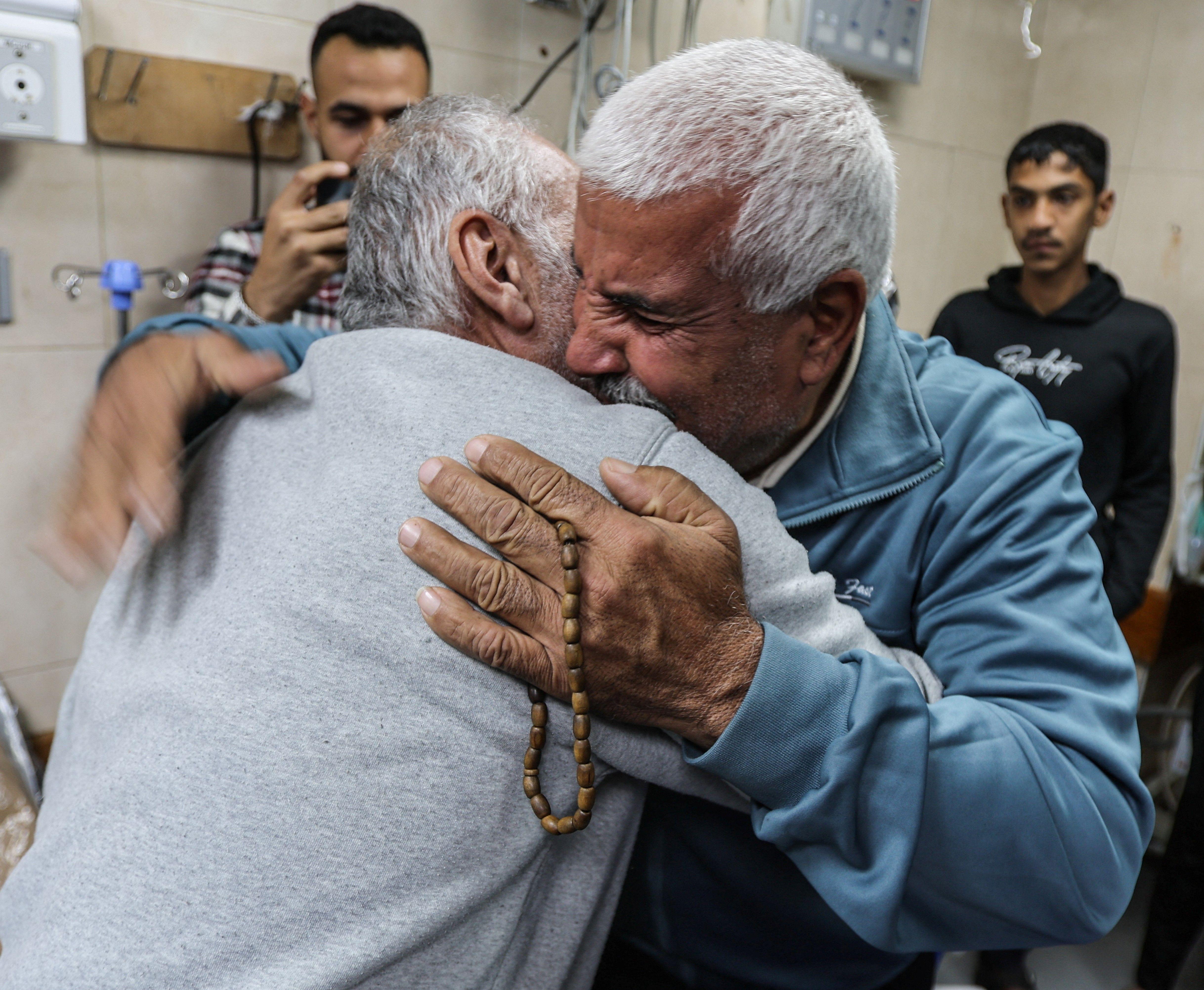 اثنان من المفرج عنهم يتعانقان في مستشفى شهداء الأقصى بعد إطلاق سراحهما، في دير البلح، وسط قطاع غزة، 10 أبريل/نيسان 2025