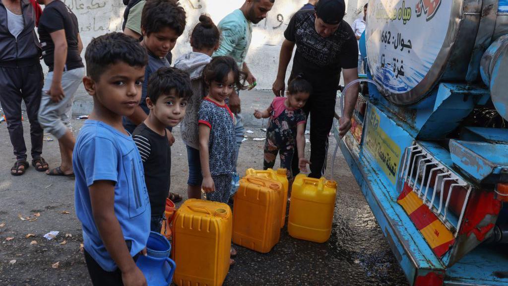 Warga Palestina mengisi jerigen mereka dengan air dari tempat pengumpulan air umum di Kota Gaza, Kamis (12/10).