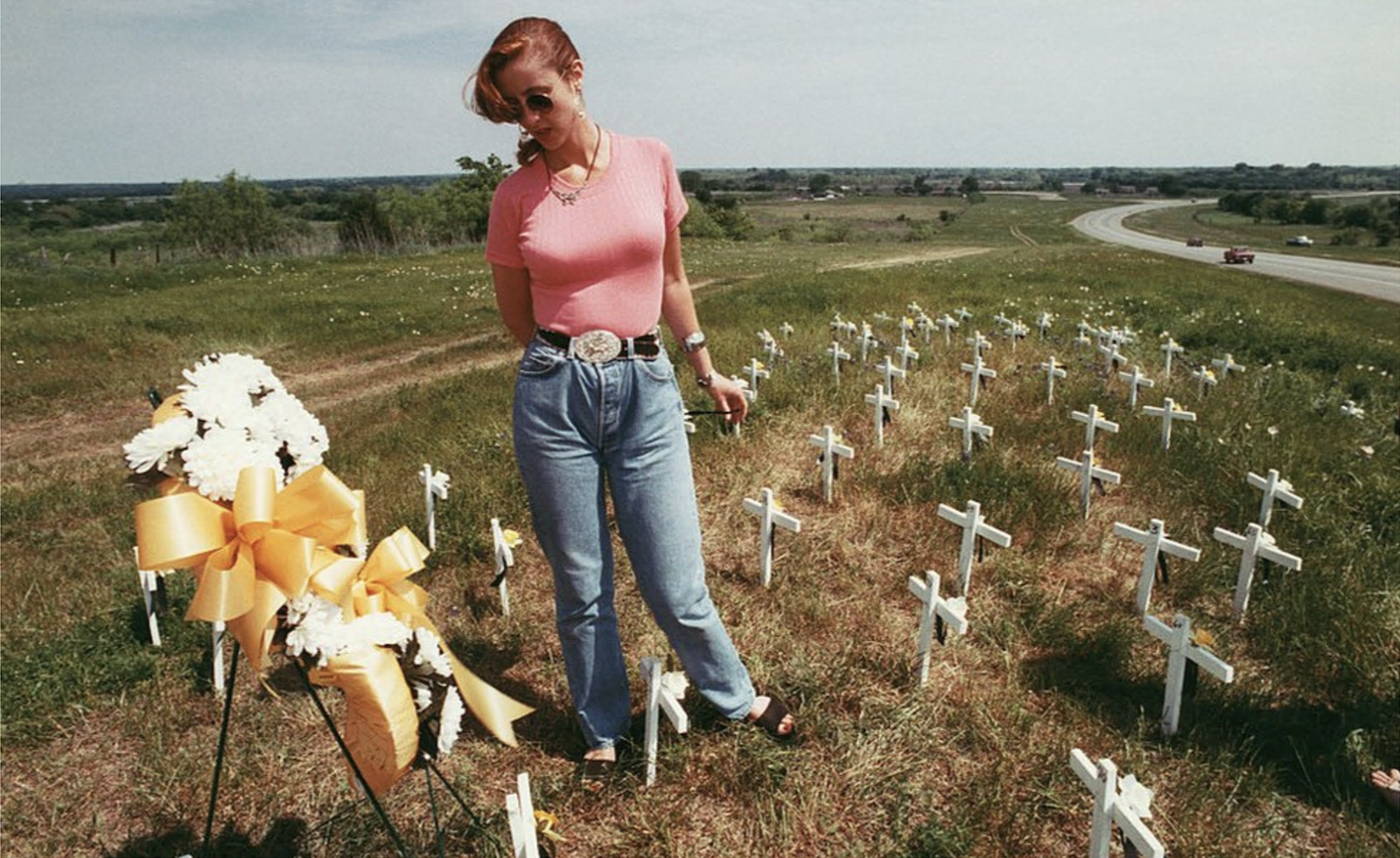 Uma mulher parada está entre os túmulos das vítimas da tragédia de Waco