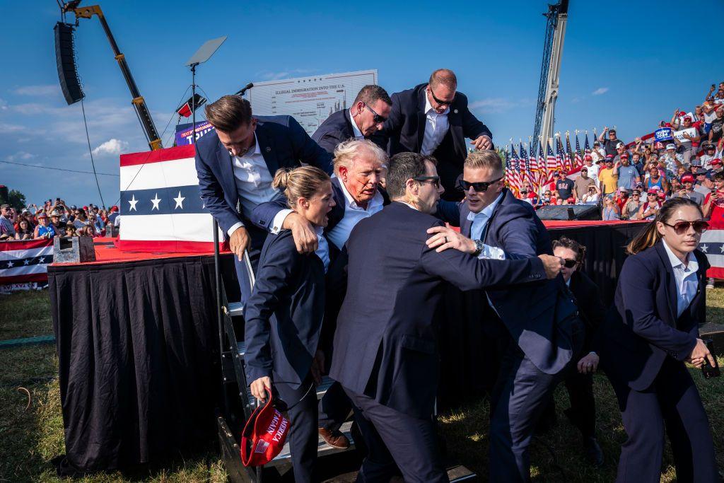 Agentes del Servicio Secreto bajan a Donald Trump del escenario. 
