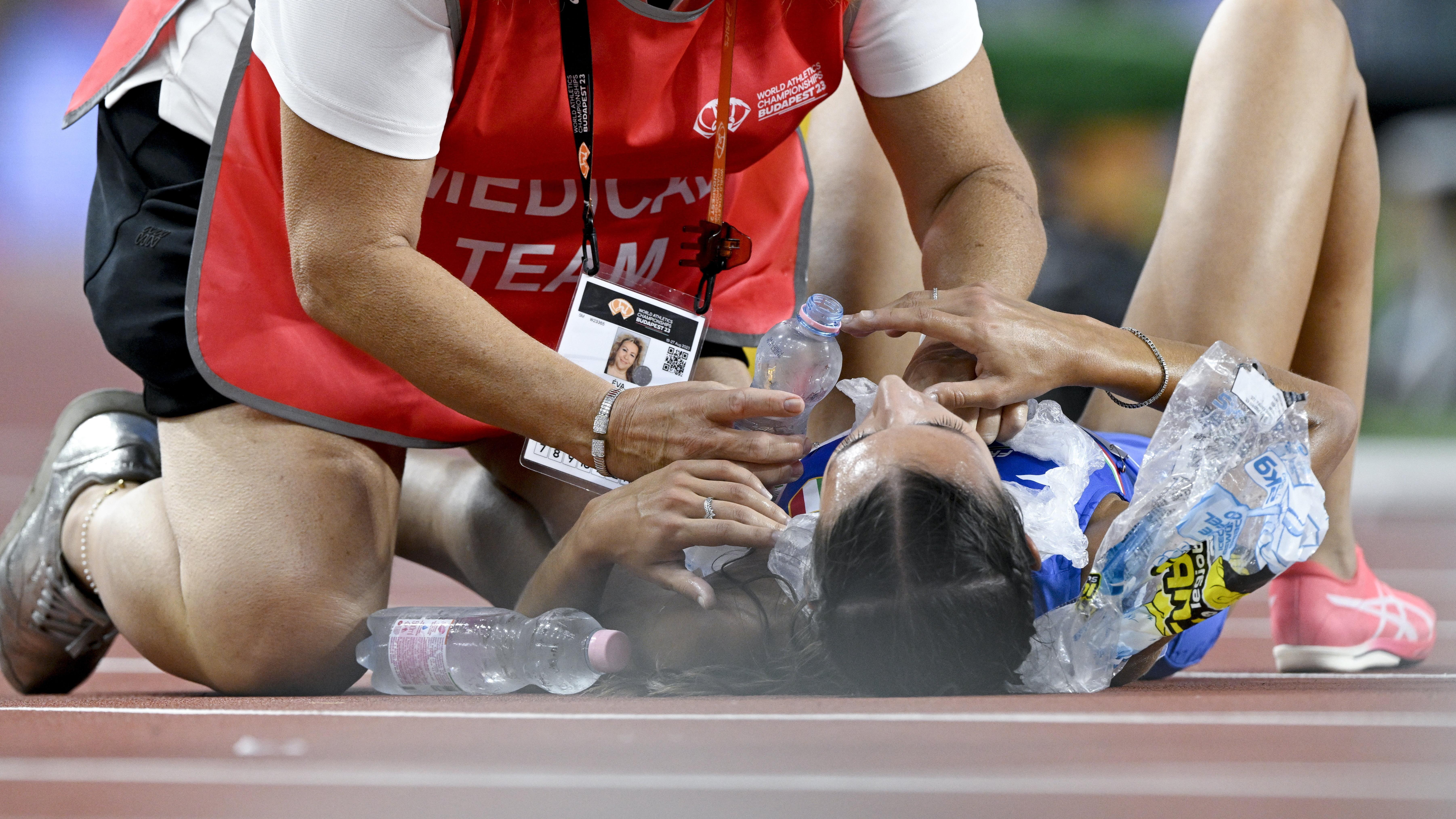 لاعبة يتم تبريدها من قبل أحد المسؤولين بعد تصفيات سباق 5000 متر للسيدات في بطولة العالم لألعاب القوى، في بودابست، المجر، 23 أغسطس/آب 2023.