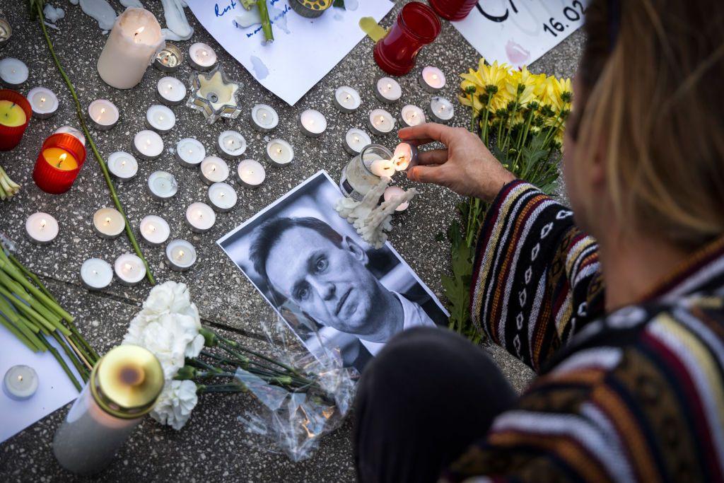 Una mujer enciende una vela junto a una foto de Navalny en Lisboa.
