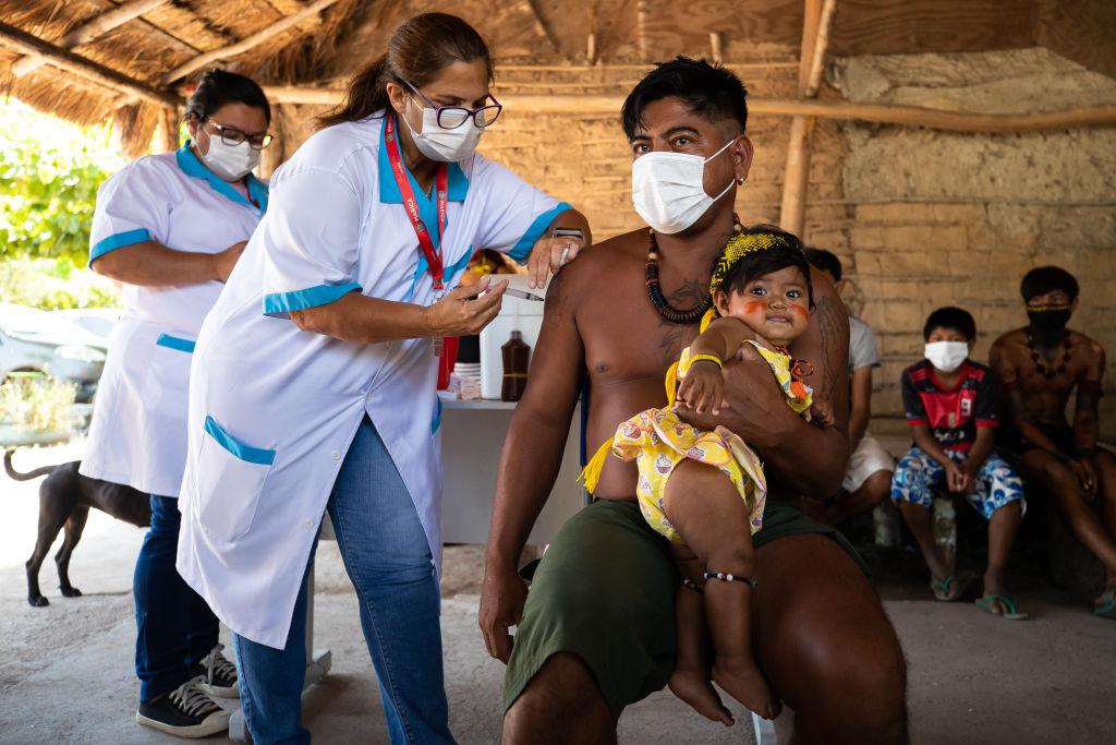 Indígena Guarani recebe vacina CoronaVac da enfermeira Rosane das Neves durante campanha de vacinação contra Covid-19 na Aldeia Mata Verde Bonita (Tekoa Ka'Aguy Ovy Porã) em 20 de janeiro de 2021 em Marica (RJ), Brasil.