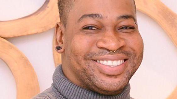 Retrato de Orden David, um homem negro sorrindo para a câmera 