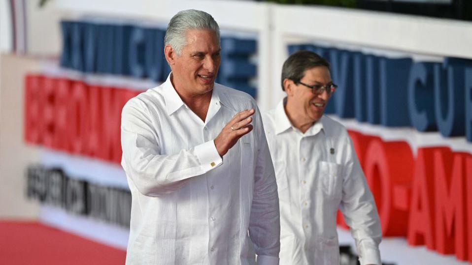 Miguel Díaz-Canel e Bruno Rodríguez Parrilla sorrindo enquanto caminhava em um tapete vermelho em um evento