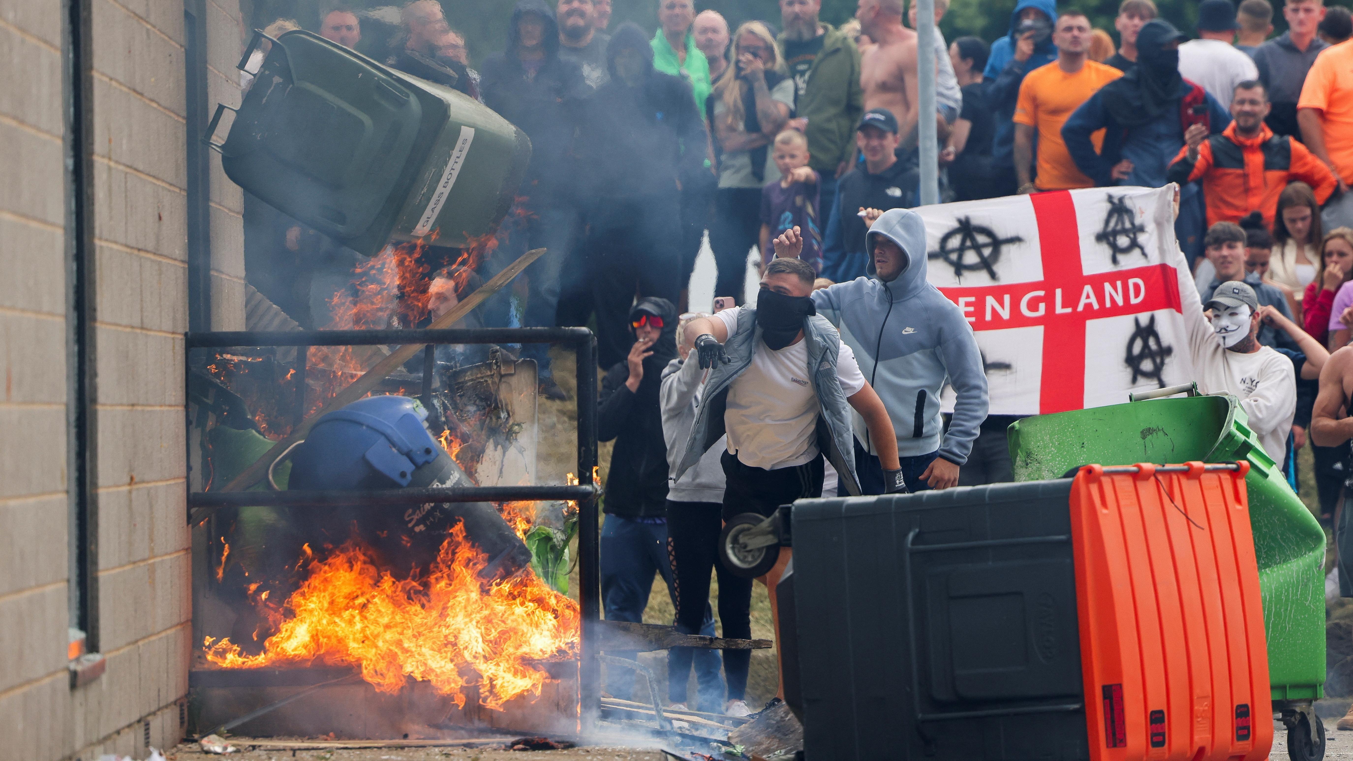 Protesters throw a bin on fire outside a hotel in Rotherham