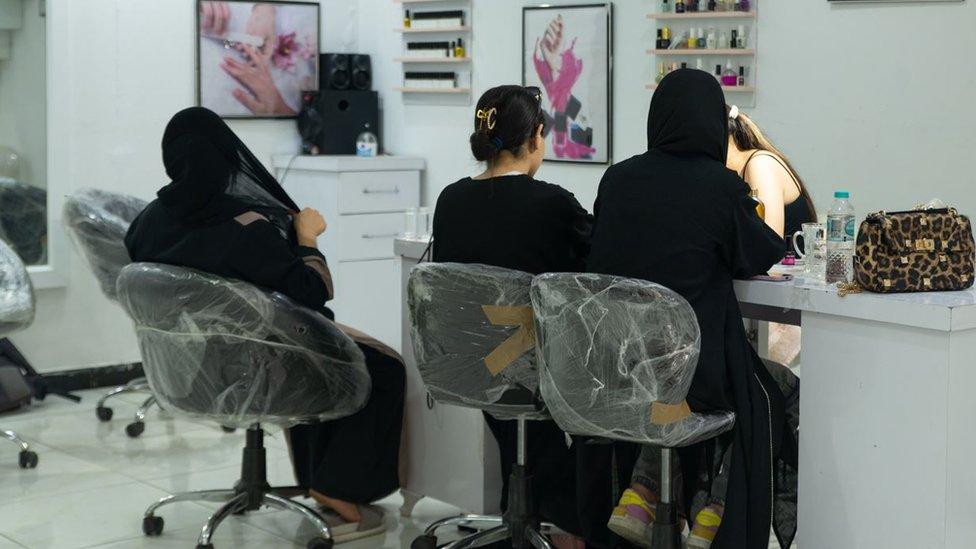Tres mujeres sentadas en un salón de belleza en Kabul
