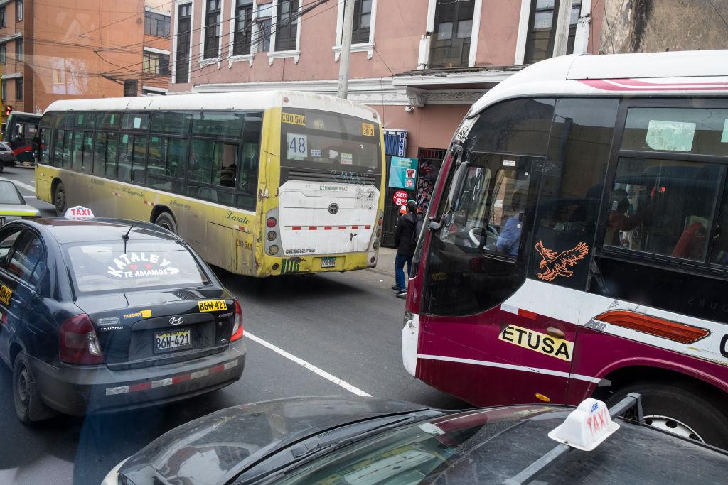 Autos y buses detenidos en una calle de Lima.