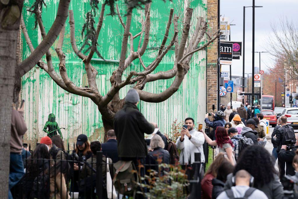 Personas junto al mural de Banksy en Finsbury Park