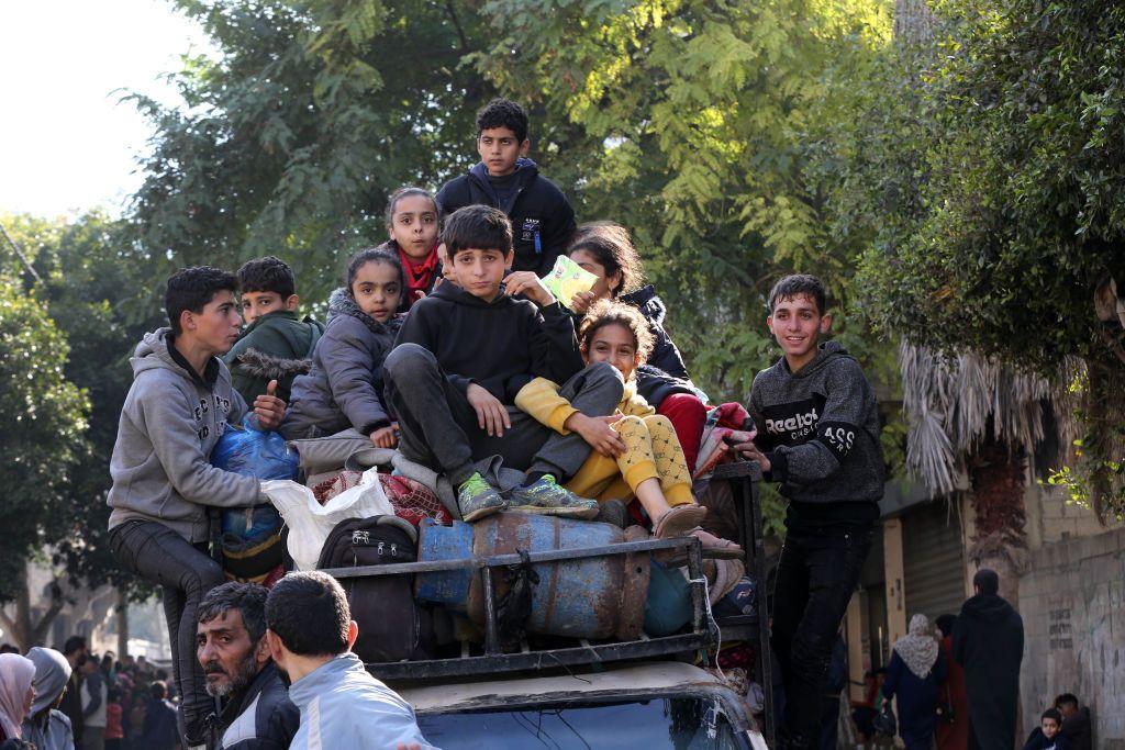 Jóvenes palestinos abandonan sus hogares en búsqueda de lugares más seguros en Gaza mientras continúan los ataques israelíes, el 4 de enero de 2024.