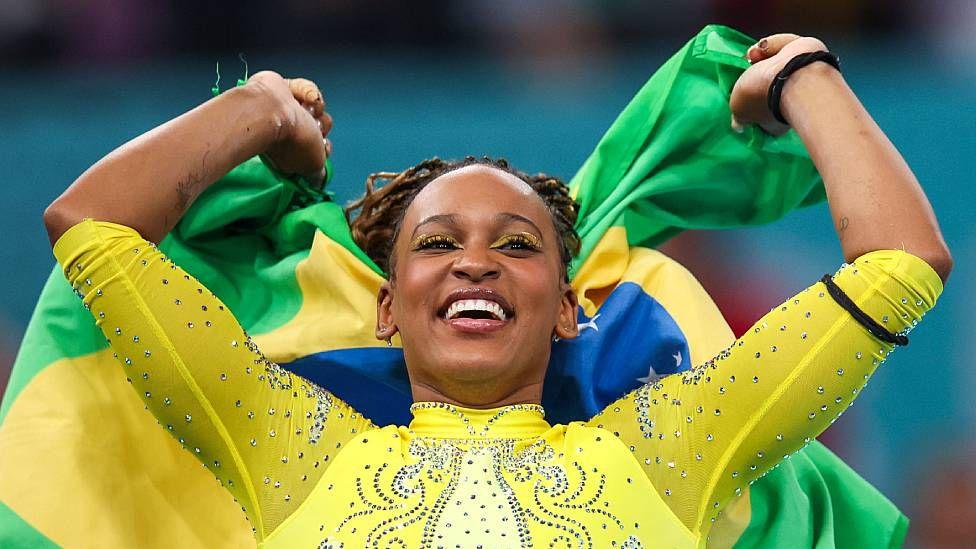 Rebeca Andrade sonriente con la bandera de Brasil