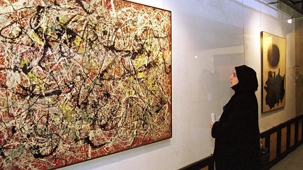 A female visitor, views 'Mural On Indian Red Ground', by American abstract expressionist painter Jackson Pollock, at the Tehran Museum of Contemporary Art, September 1999