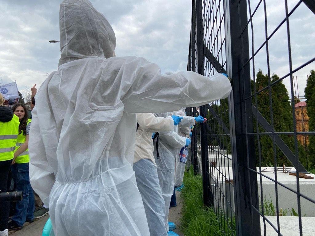 Studenti i sugrađani u zaštitnom odelu čiste ogradu nedaleko od televizije Informer