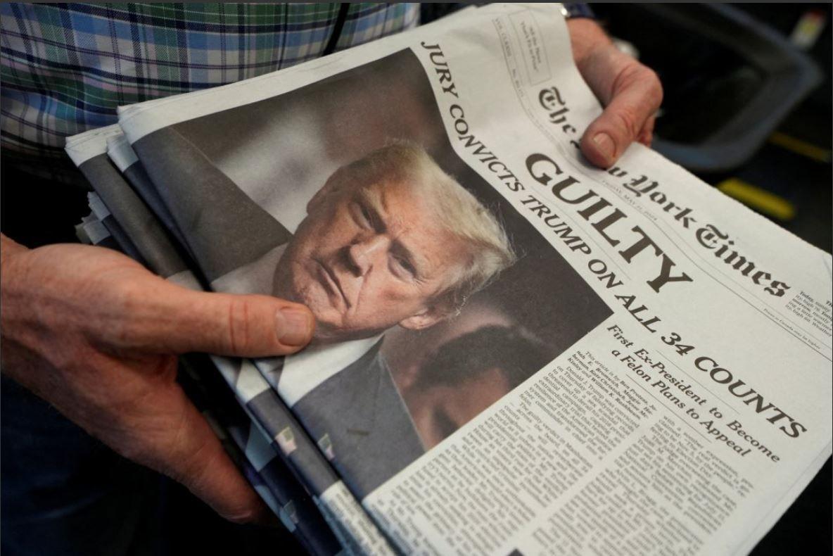 Una persona sostiene los periódicos del New York Times mientras se imprimen, tras el anuncio del veredicto sobre el juicio penal del ex presidente estadounidense Donald Trump, por cargos de falsificar registros comerciales para ocultar dinero pagado para silenciar a la estrella de cine para adultos Stormy Daniels en 2016.