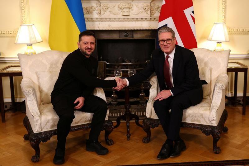 Presidente Zelensky da Ucrânia e o primeiro-ministro britânico Keir Starmer sentados, cumprimentando-se