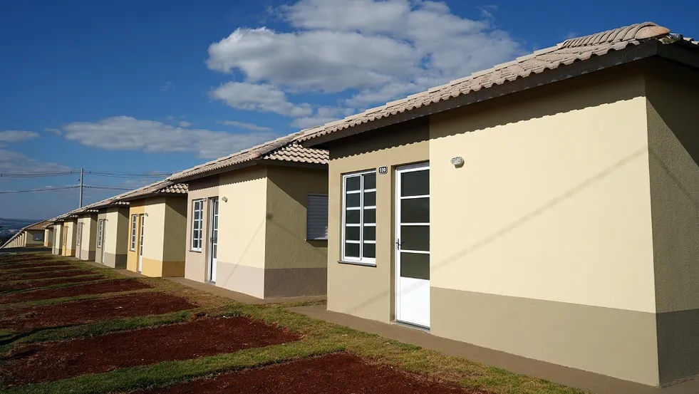 Foto mostra uma série de casas amarelas construídas pela construtora Pacaembu, elas são padronizadas, pintadas de amarelo com portas brancas