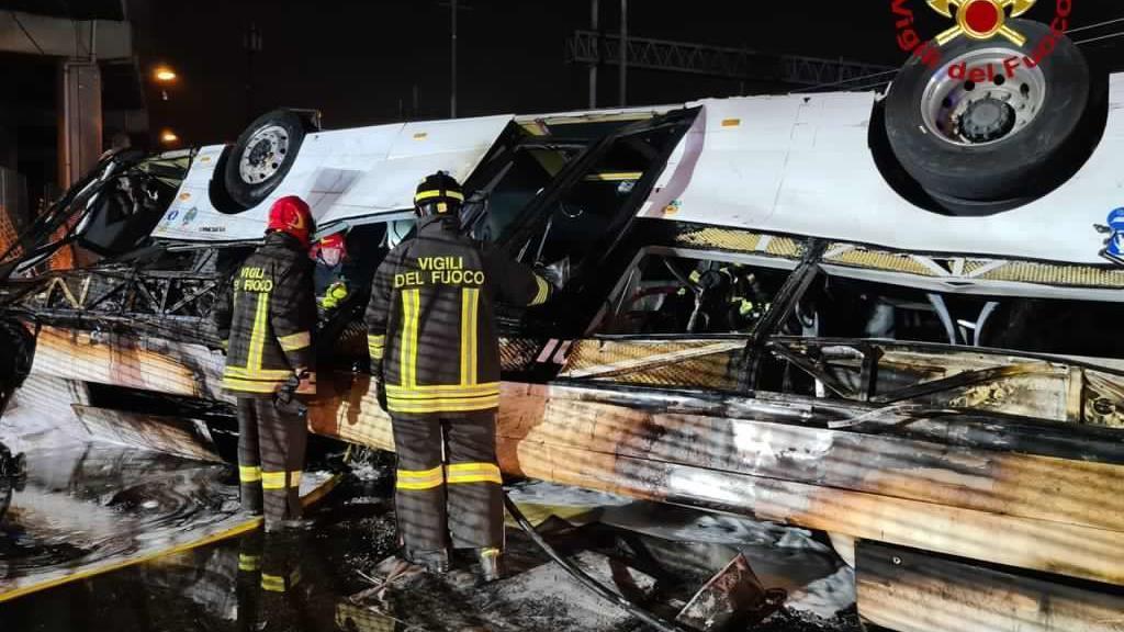 Restos del autobús vigilados por los bomberos.