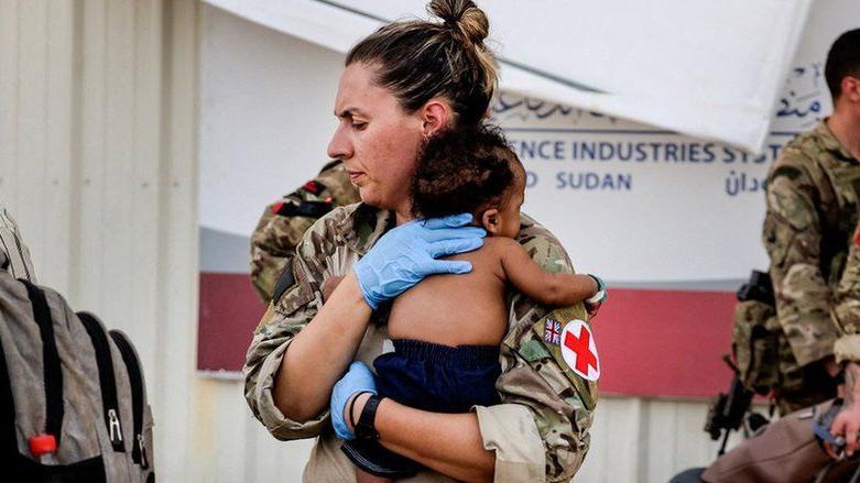 مسعفة عسكرية تحمل طفلا أثناء إجلاء بريطانيين في السودان