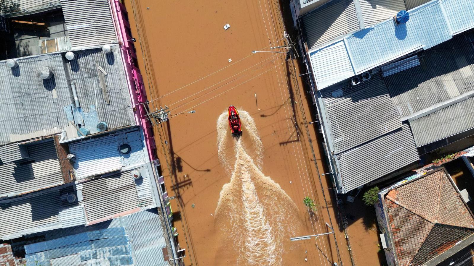 Barco transita por bairro completamente alagado