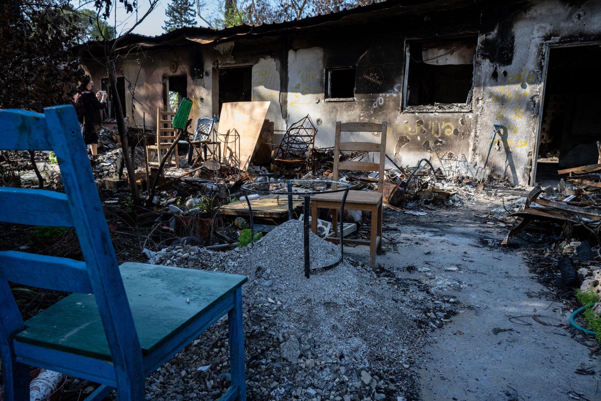 Cadeiras ao lado de pilhas de destroços queimados peneirados para encontrar restos humanos, enquanto os residentes israelenses do kibutz Nir Oz lutam contra a invasão por militantes palestinos do Hamas da vizinha Faixa de Gaza, em 6 de dezembro de 2023