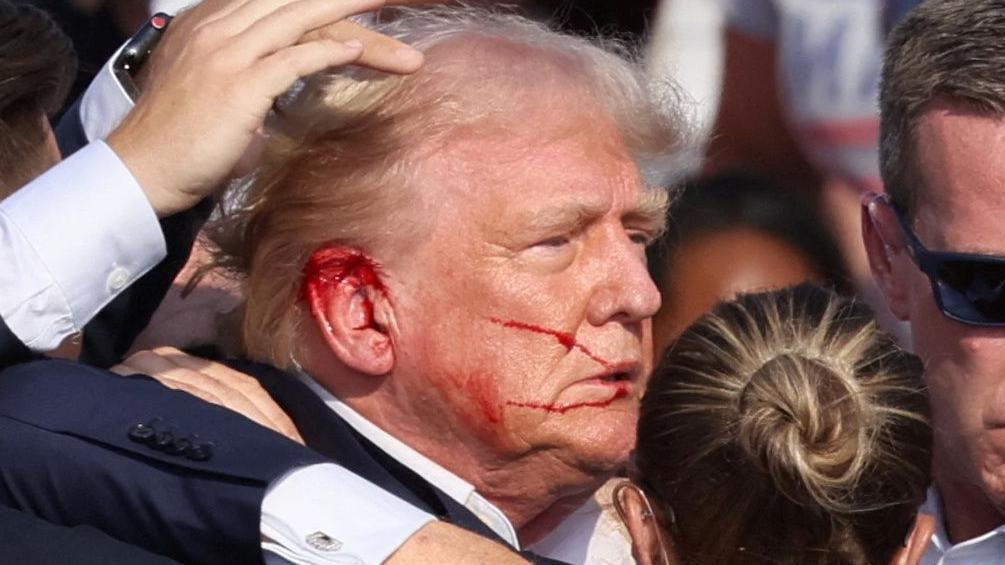 Trump tras ser herido por una bala en la oreja.