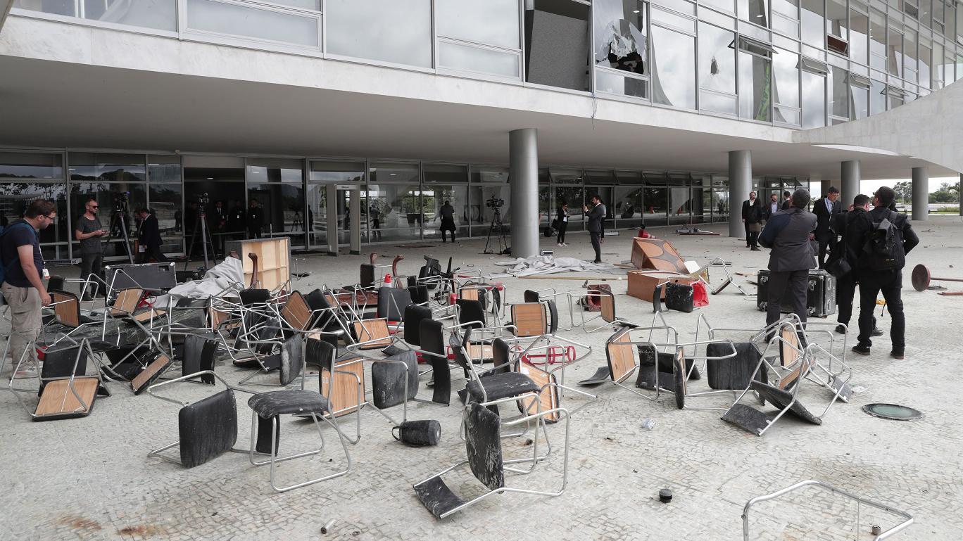 Imagem de destruição provocada pelos ataques, com cadeiras fora do prédio do Planalto