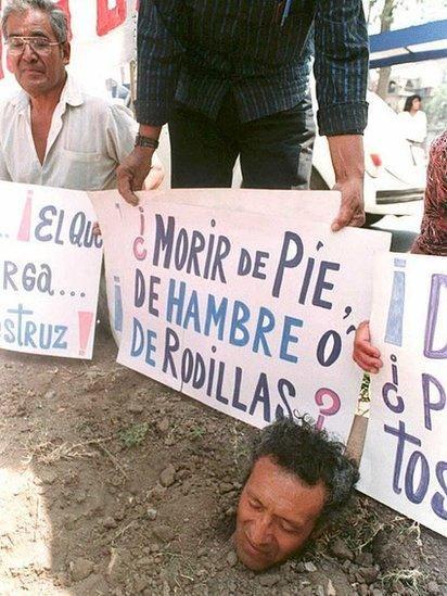 Un  hombre protesta enterrándose 