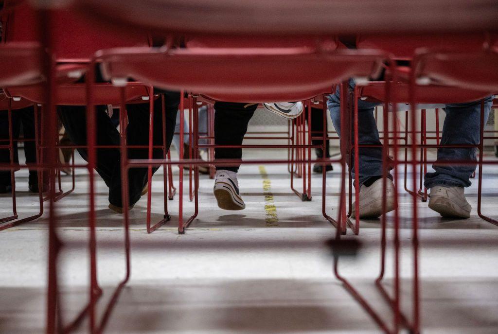 Un niño (C) balancea sus pies junto a sus padres durante una presentación del Centro Amica para los Derechos de los Inmigrantes (anteriormente conocido como Coalición CAIR) sobre la aplicación de la ley de inmigración en una escuela en Washington, DC el 10 de enero de 2025.(Foto de ANDREW CABALLERO-REYNOLDS / AFP) (Foto de ANDREW CABALLERO-REYNOLDS/AFP vía Getty Images)