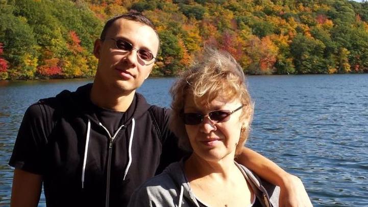 Roman Mussabekov abraça sua mãe beira de um lago 