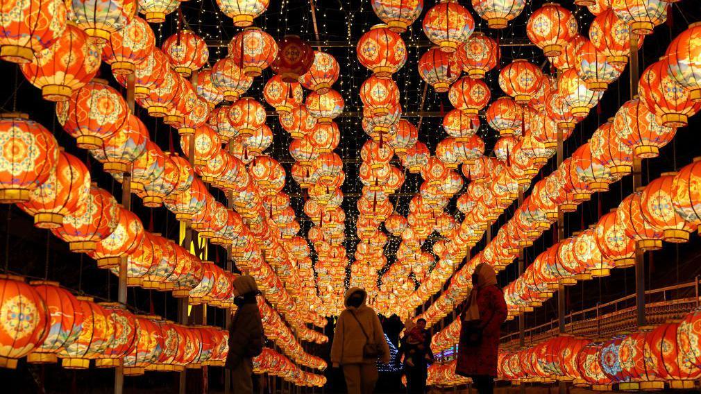 Visitantes entre lanternas vermelhas iluminadas para celebrar o Festival da Primavera na China