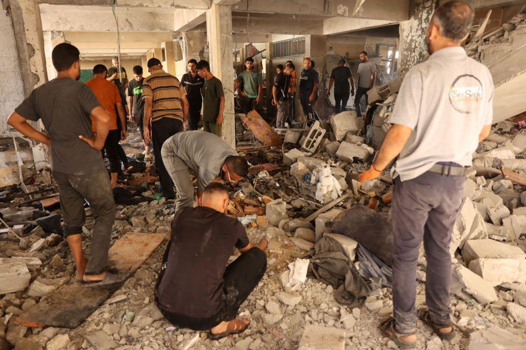 Hombres buscando entre los escombros a sobrevivientes del ataque contra la escuela de Gaza del sábado 21 de septiembre.