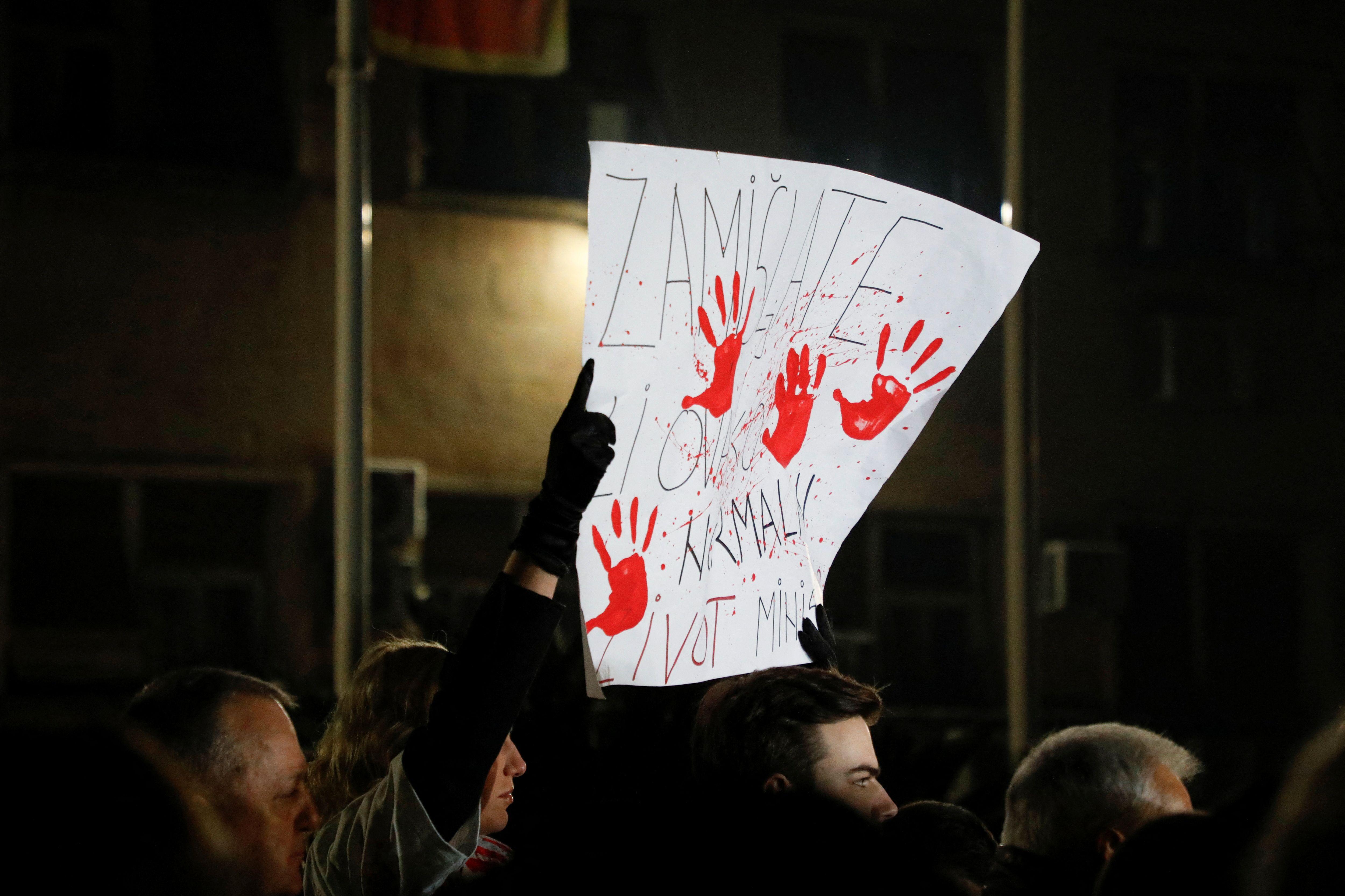 Protest u Podgorici 5. januara, demonstranti drže u rukama beli plakat sa crvenim krvavim rukama