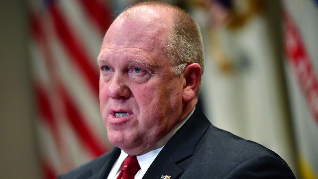 Tom Homan en una rueda de prensa con la bandera de Estados Unidos al fondo.