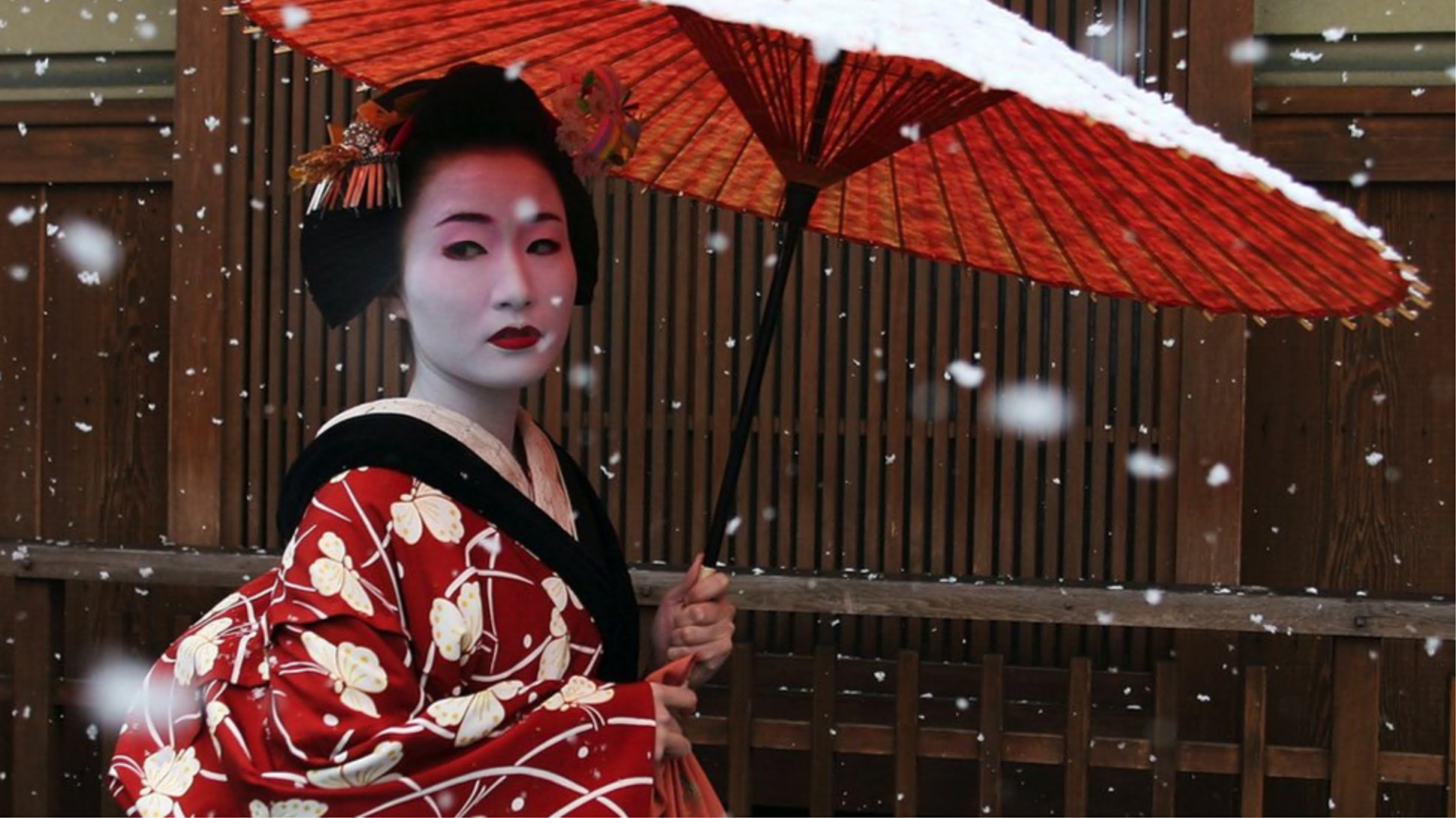A Maiko, a traditional Japanese dancer, walks in the snow in Gion, Kyoto's famous geisha district, January 7, 2006 in Kyoto, Japan.