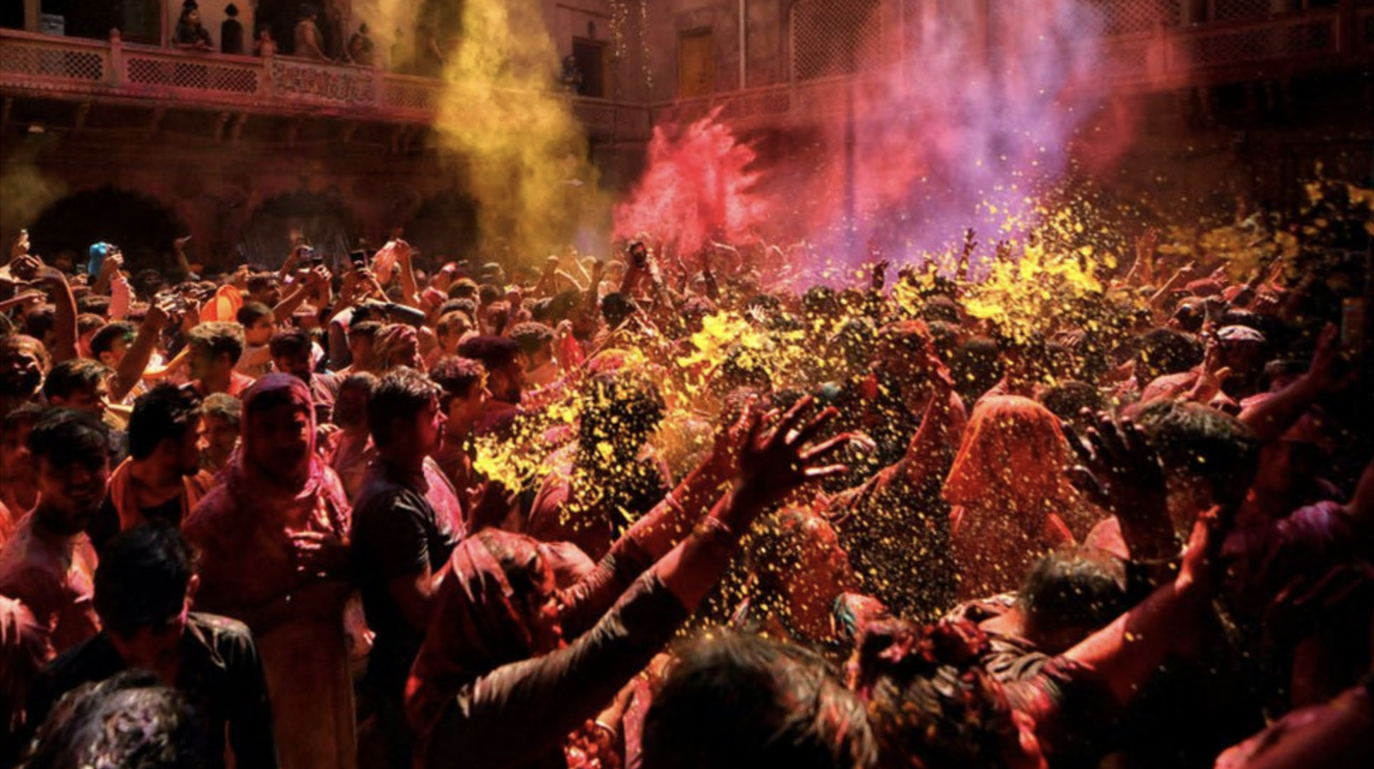  Hindu devotees pray at Radha Ballav Temple during the holi festival with colourful powders