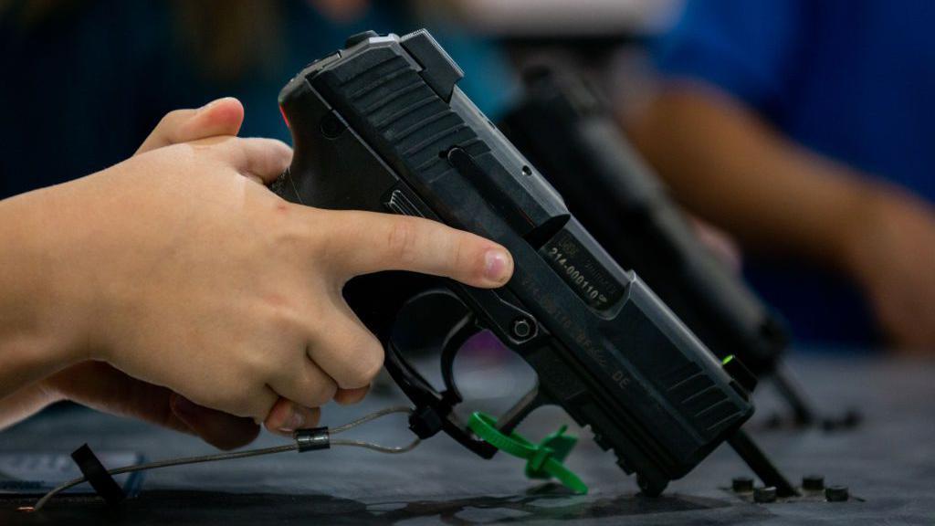 Niño empuña un arma de la Convención de la Asociación Nacional del Rifle