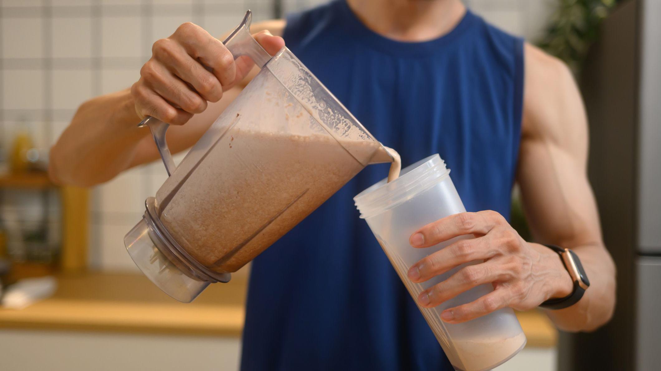 persona vierte una mezcla de proteína en un vaso 