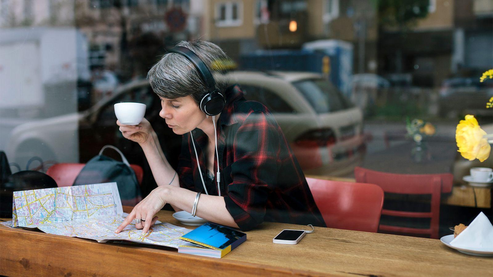 mulher lendo mapa em um café